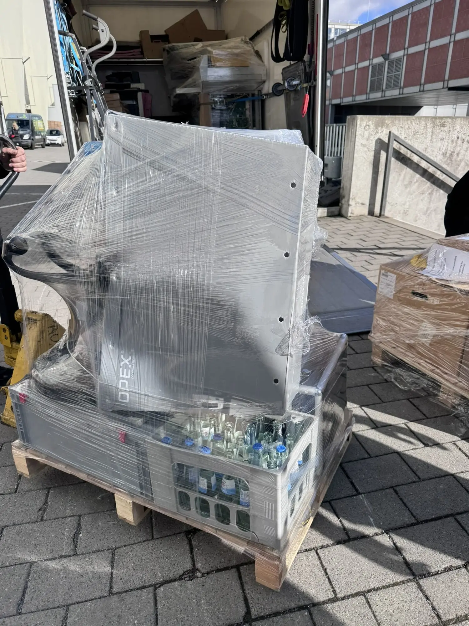 In Stretchfolie verpackter Scanner auf einer Palette vor der Messehalle