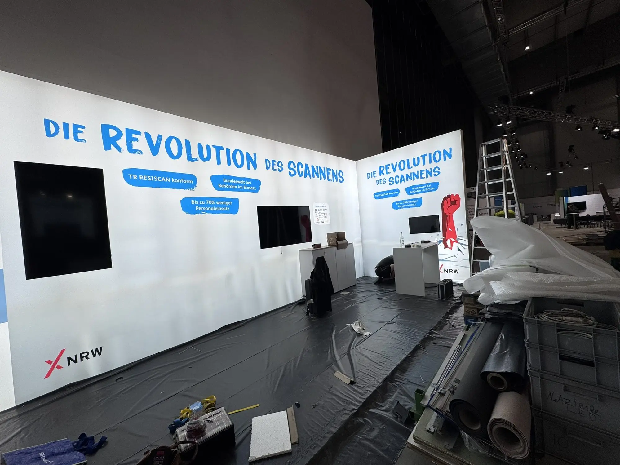 Der noch leere Stand mit Markenwand, abgedecktem Boden und Werkzeug